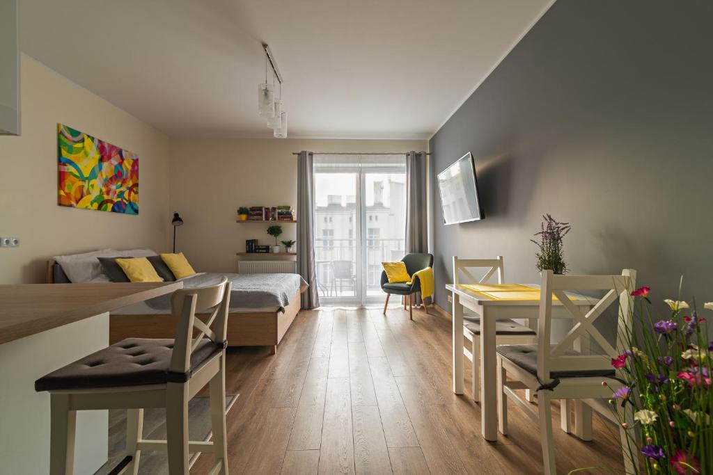 a bedroom with a bed and a table and chairs at Apartamentylove - Apartament Więckowski in Łódź