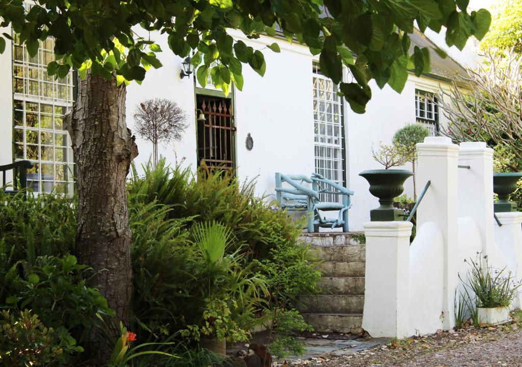 a white house with a tree in the yard at Moolmanshof 1798, Traditional Cape Dutch H-Shaped Farmhouse in Swellendam