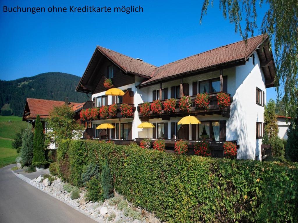 ein Gebäude mit Blumen am Straßenrand in der Unterkunft Gästehaus Böck in Pfronten in Pfronten