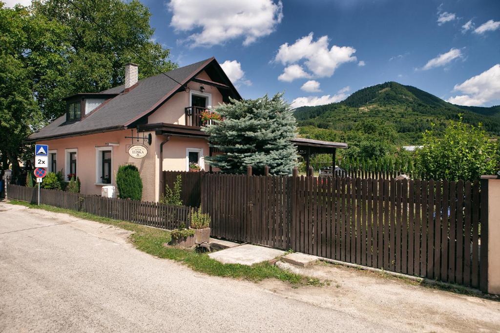 a house with a fence next to a road at Prázdninový dom Eliška*** in Rajecká Lesná