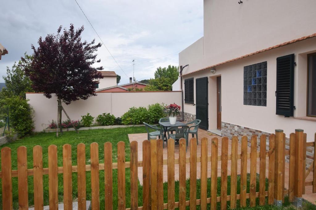 a wooden fence in front of a house with a table at Margherita Monolocale in Marina di Campo