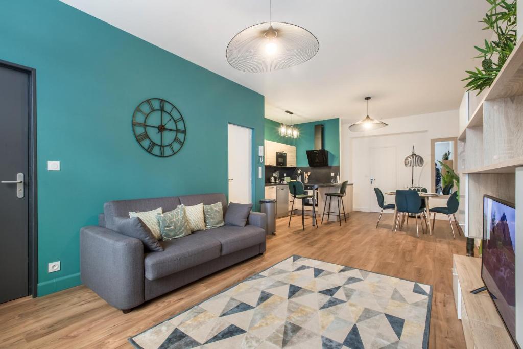 a living room with a couch and a blue wall at Résidence Sénac in Valenciennes