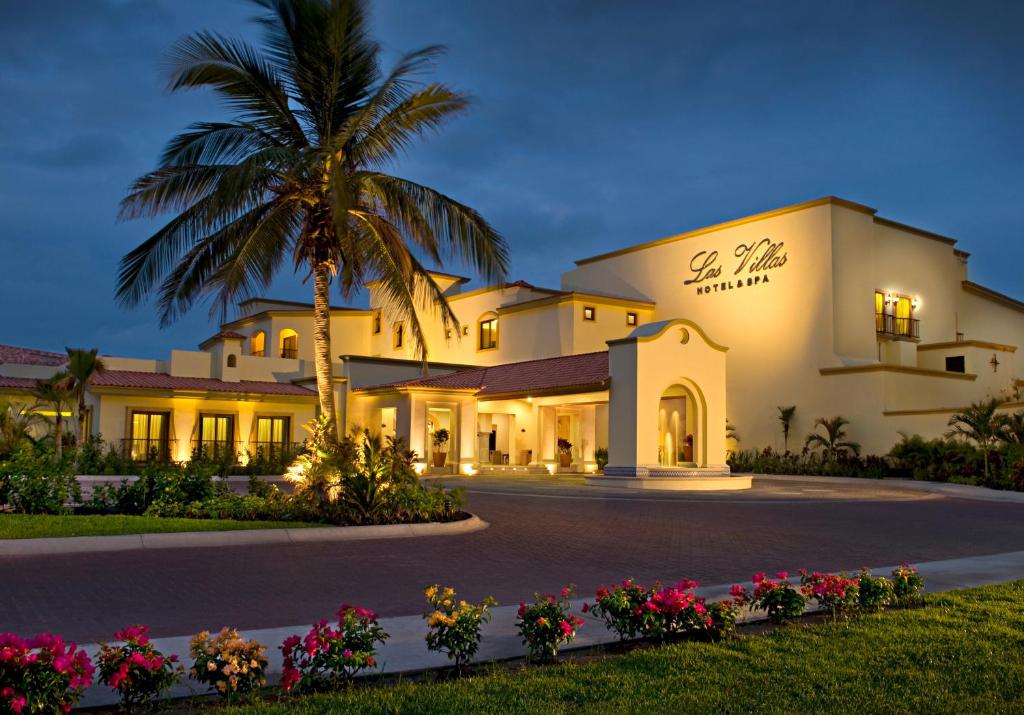 un bâtiment avec un palmier en face dans l'établissement Las Villas Hotel & Golf By Estrella del Mar, à Mazatlán