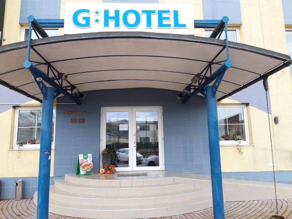 ein Gebäude mit einer Markise vor einem Hotel in der Unterkunft Garni G Hotel Žilina in Žilina