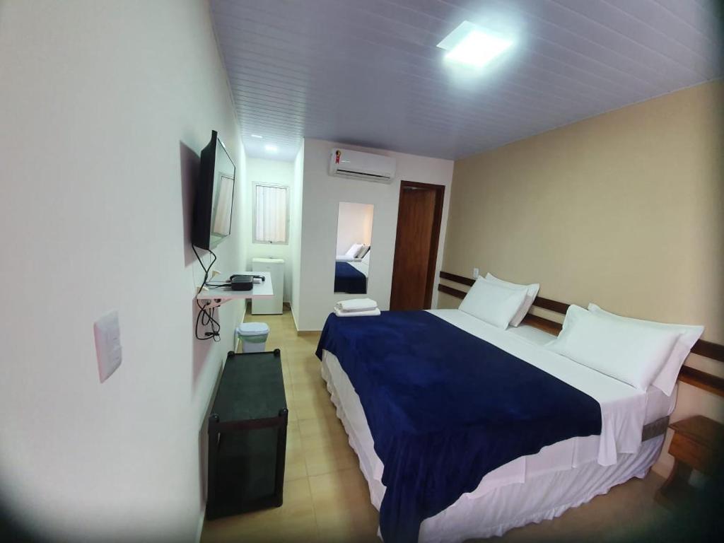 um quarto de hotel com uma cama e uma televisão em Casa do Maneco em Fernando de Noronha