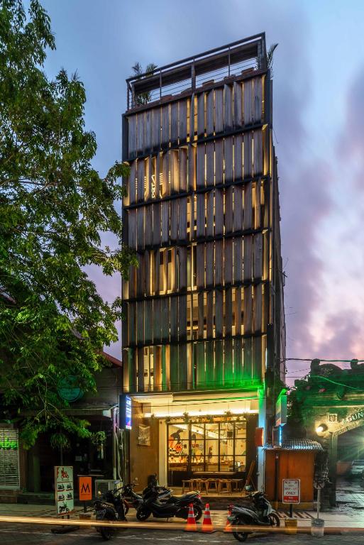 a tall building with motorcycles parked in front of it at M Boutique Hostel Legian in Legian