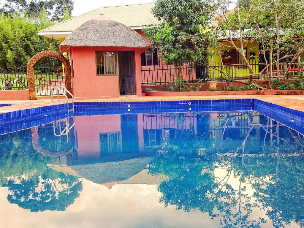 a house with a swimming pool in front of a house at Governors Club in Entebbe