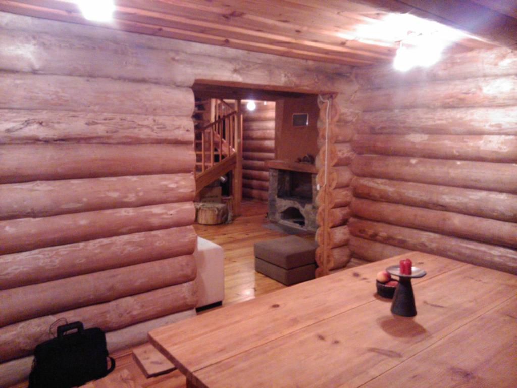 Cabaña de madera con mesa y chimenea en Hundi Holiday House, en Kolodavitsa
