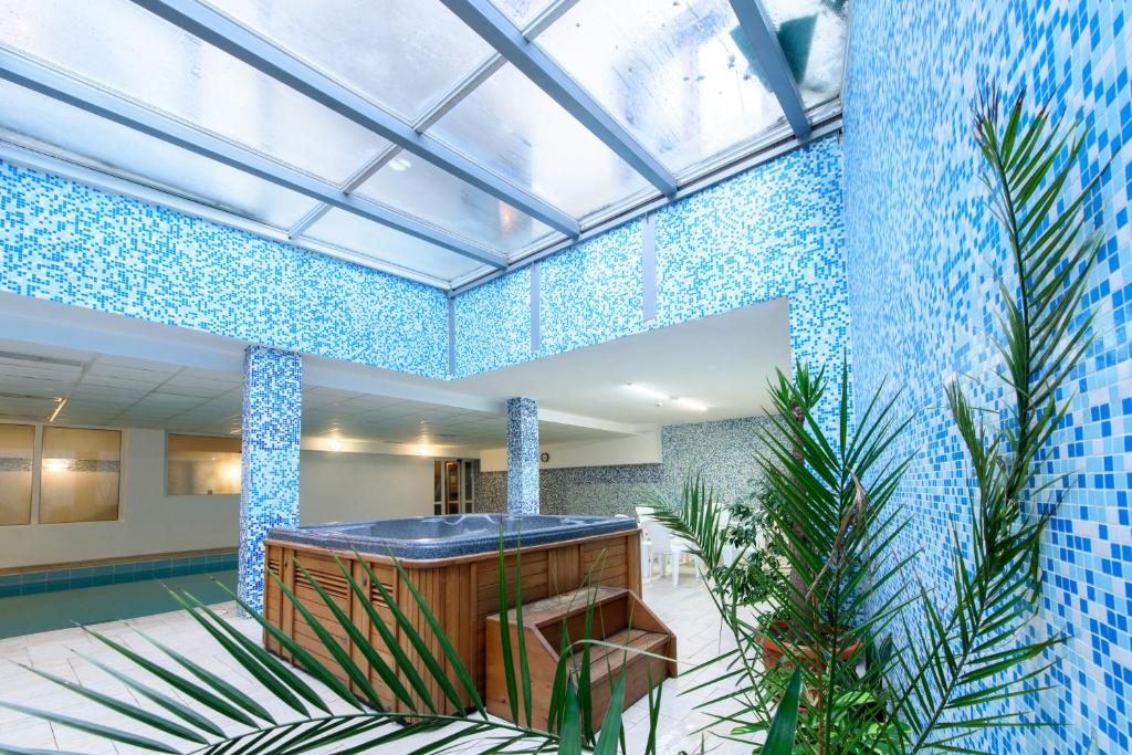 a lobby with blue tile walls and plants at Kap House Family Hotel in Bansko