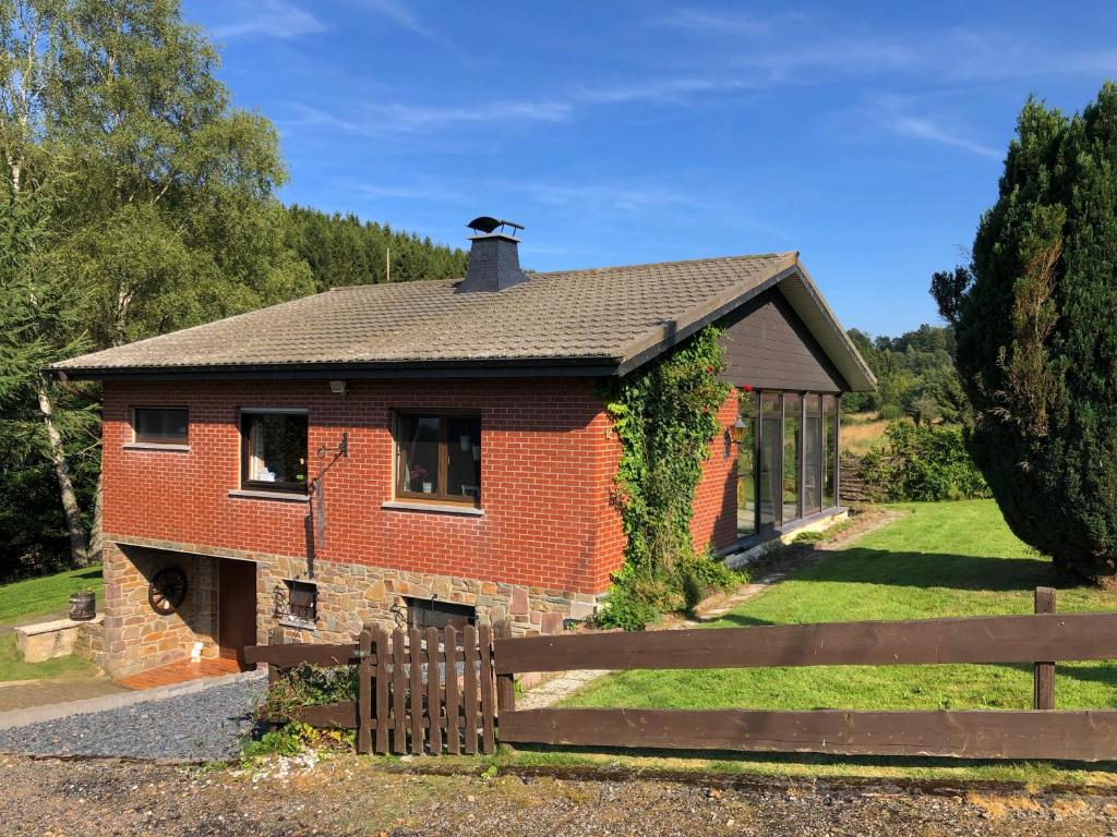 una casa de ladrillo con una valla delante de ella en Ferienhaus Maison Idylle im Hohen Venn - Monschau en Butgenbach