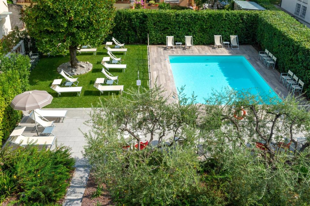 a patio area with a pool and lawn chairs at Hotel San Marco in Lucca