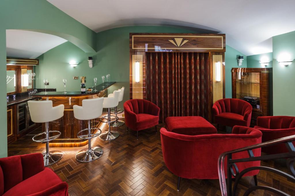 a bar with red chairs and a counter in a room at Sea-facing Art Deco Apartment in Brighton & Hove