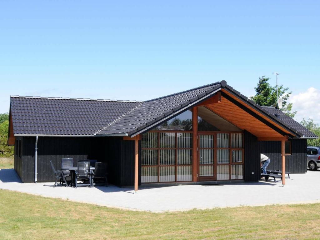 a metal roofed pavilion with a table and chairs at 8 person holiday home in Vejers Strand in Vejers Strand