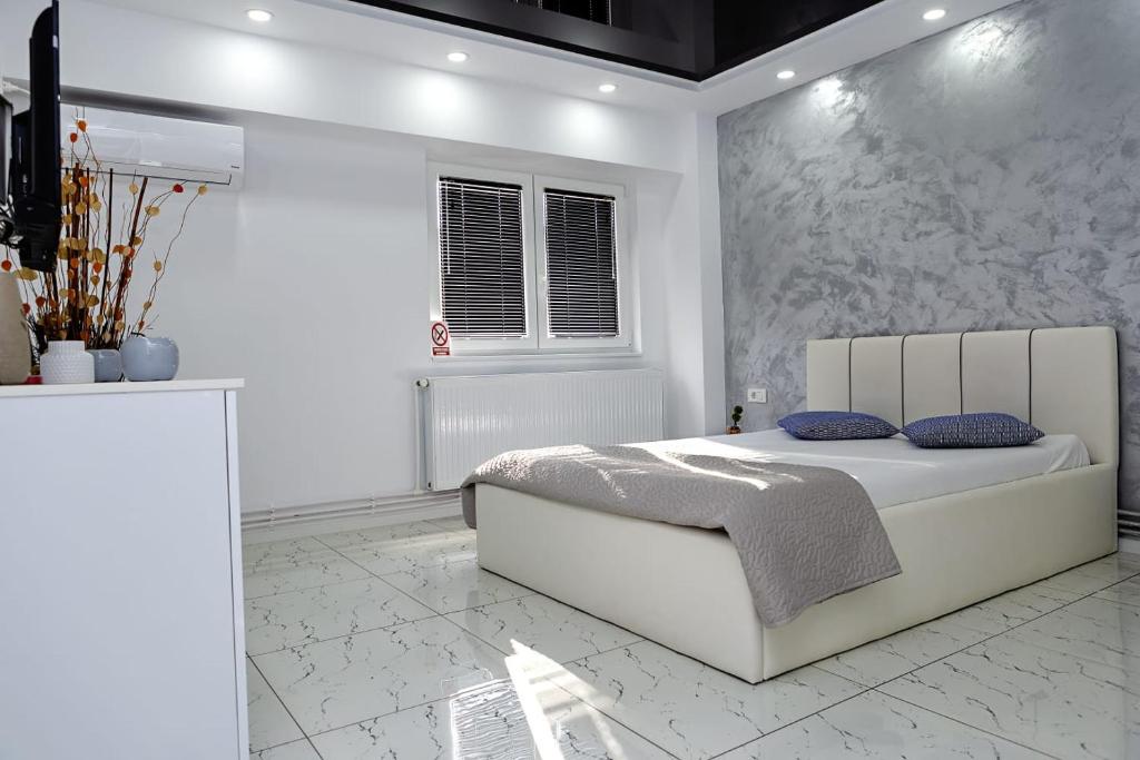 Habitación blanca con cama y ventana en Archi's Apartament, en Galaţi