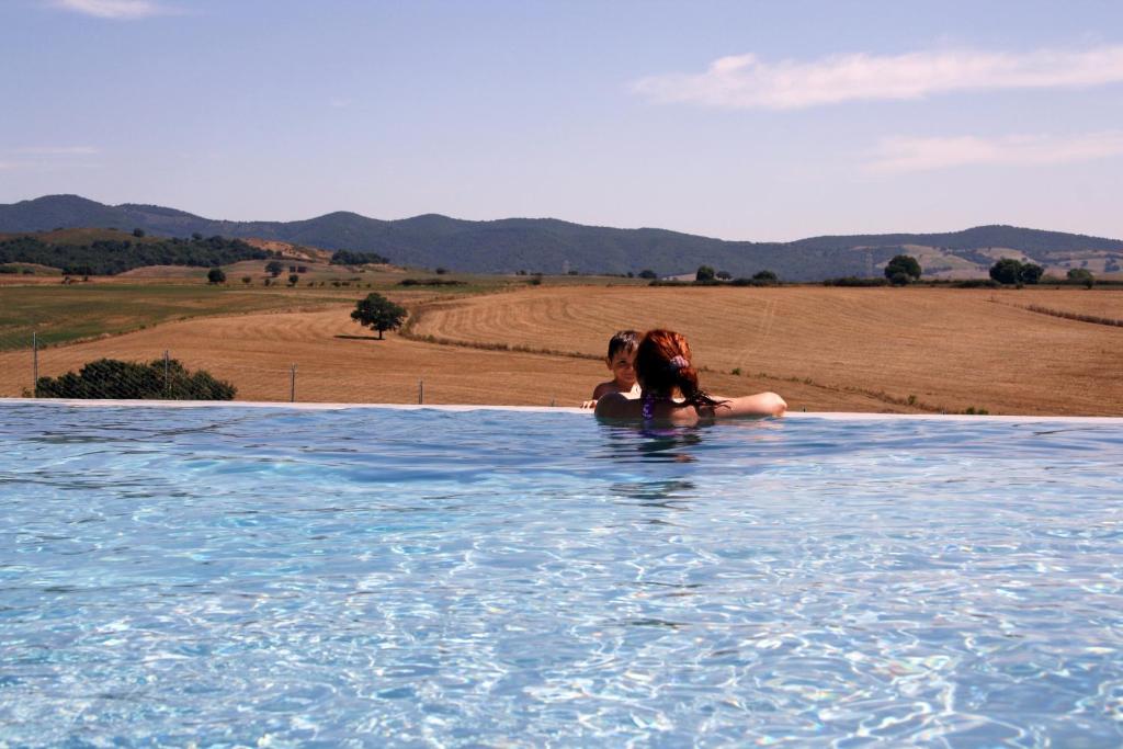 uma mulher está sentada numa piscina de água em Relais La Cerreta em Capalbio