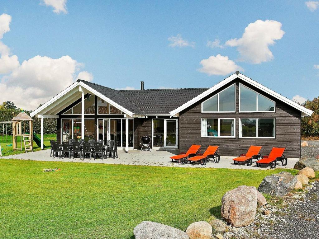 ボーゲンセにある16 person holiday home in Bogenseのオレンジの椅子が前にある家
