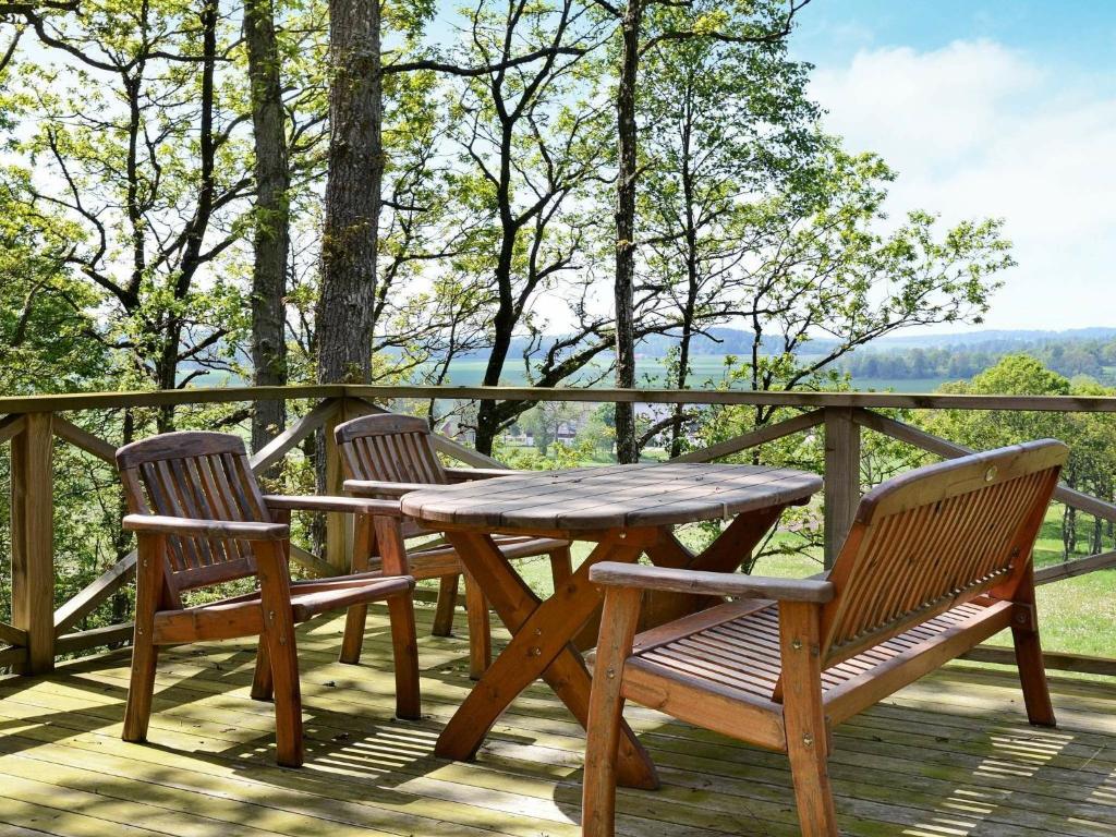 une table et des chaises en bois sur une terrasse avec vue dans l'établissement 4 person holiday home in Sl inge, à Ugglarp