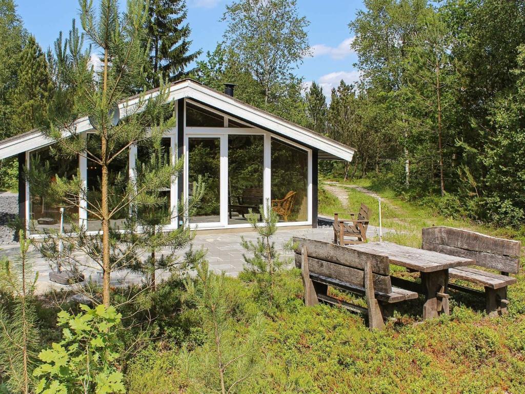 Kølkærにある5 person holiday home in Herningの野原のピクニックテーブルとベンチ付きの家