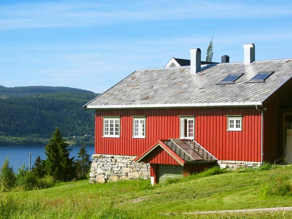 una casa roja sentada en la cima de una colina en Four-Bedroom Holiday home in Follafoss, en Vølset