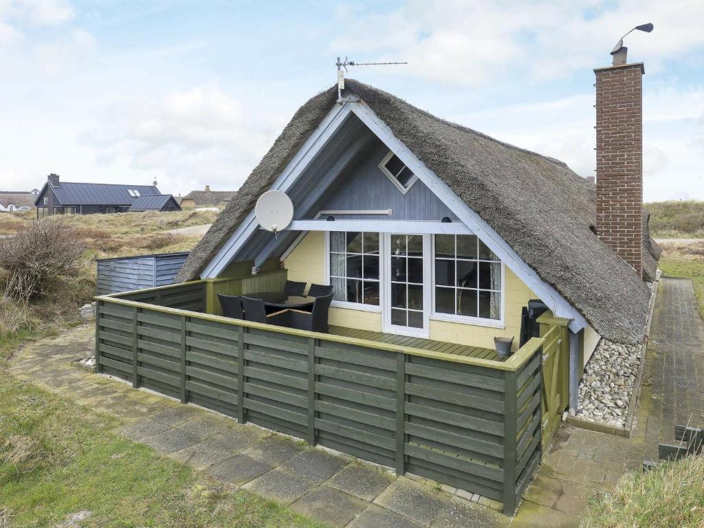 uma casa rústica com telhado de palha e telhado de palha em 6 person holiday home in Ringk bing em Klegod