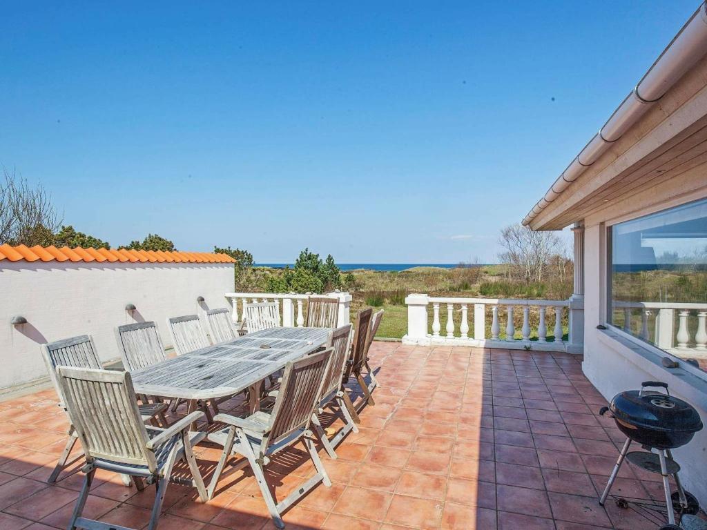 a patio with a table and chairs and a grill at Four-Bedroom Holiday home in Sjællands Odde 2 in Yderby