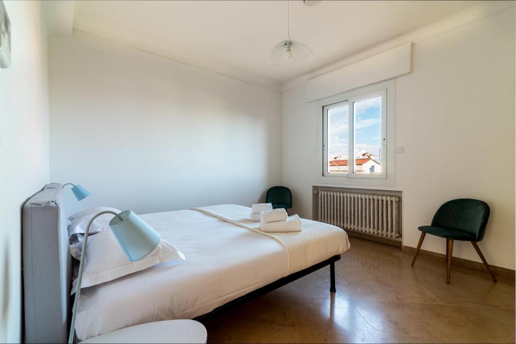 a bedroom with a bed and two chairs and a window at Villa Primavera Splendid villa with sea view in Saint-Jean Cap Ferrat in Saint-Jean-Cap-Ferrat