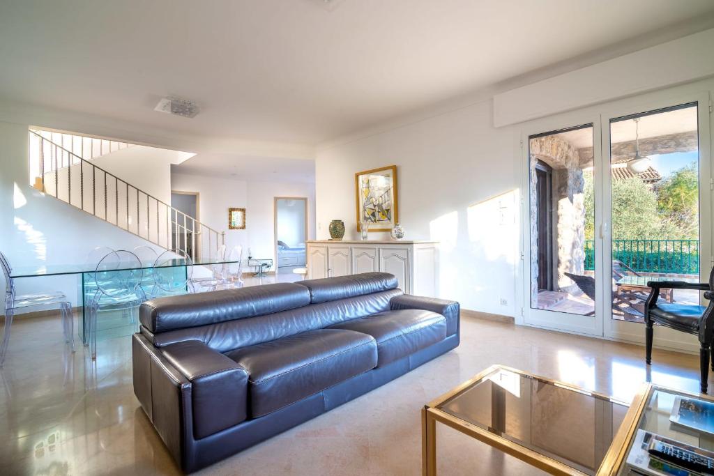 a living room with a leather couch and a glass table at Villa Primavera Splendid villa with sea view in Saint-Jean Cap Ferrat in Saint-Jean-Cap-Ferrat