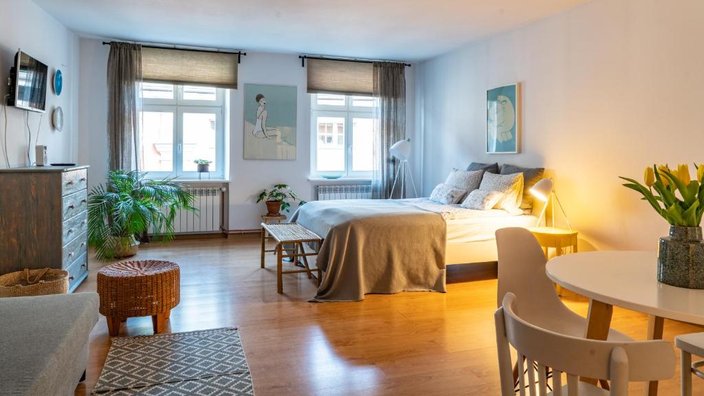 a bedroom with a bed and a table and chairs at Cocorico Apartments in Poznań