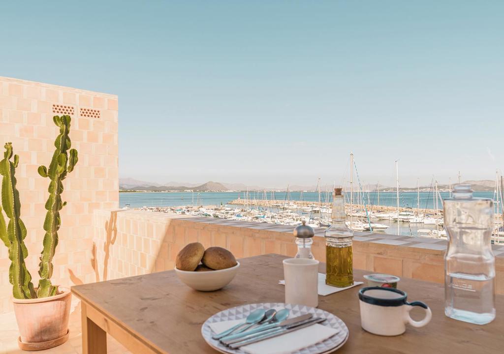 a table with a plate of food on a table with a view at Moll Petit Apartments - Turismo de Interior in Can Picafort