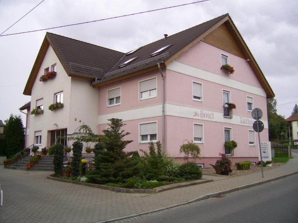 um edifício rosa e branco ao lado de uma rua em Hotel Kirchner em Tharandt