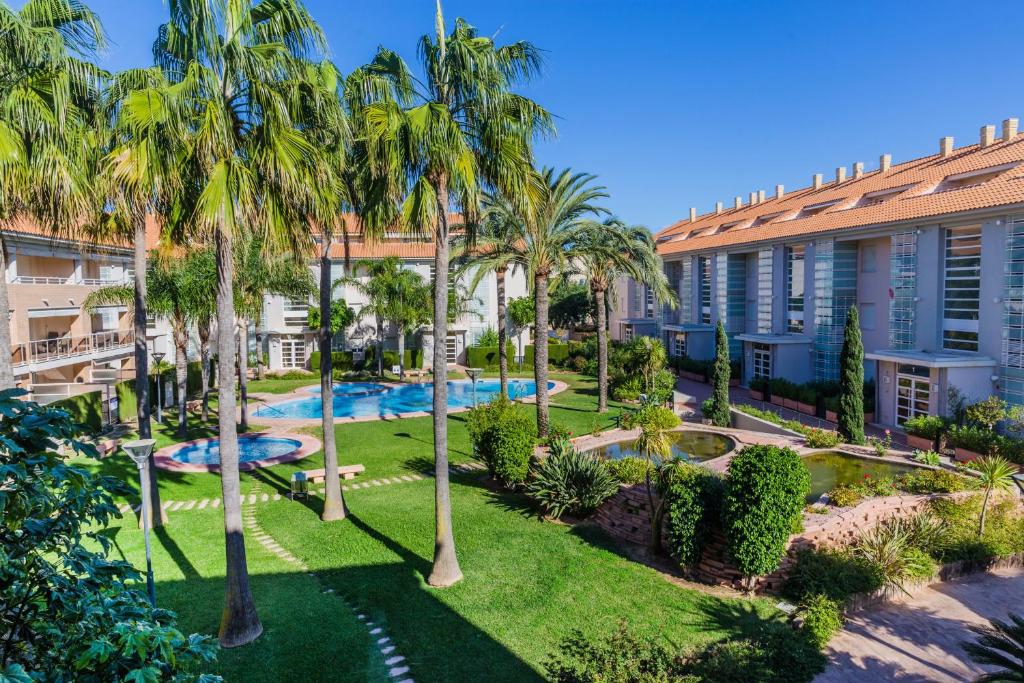 eine Luftansicht auf den Innenhof eines Gebäudes mit Palmen in der Unterkunft Golden Gardens Apartment Javea Arenal by Rock Rentals in Jávea