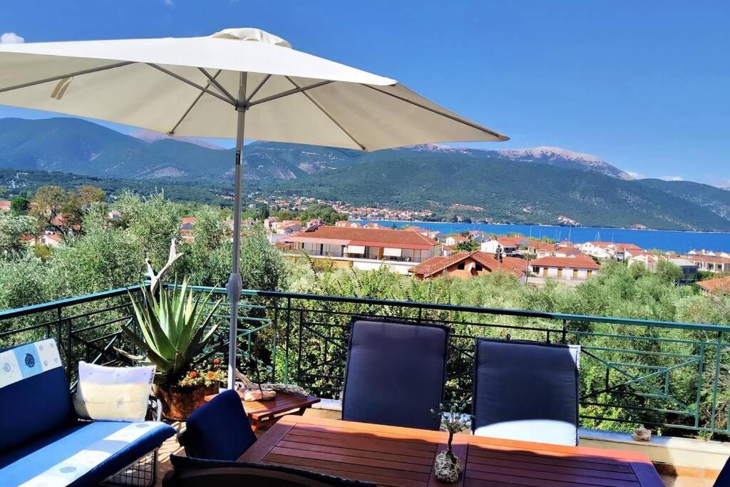 a table and chairs with an umbrella on a balcony at Fiorela maisonette in Sami