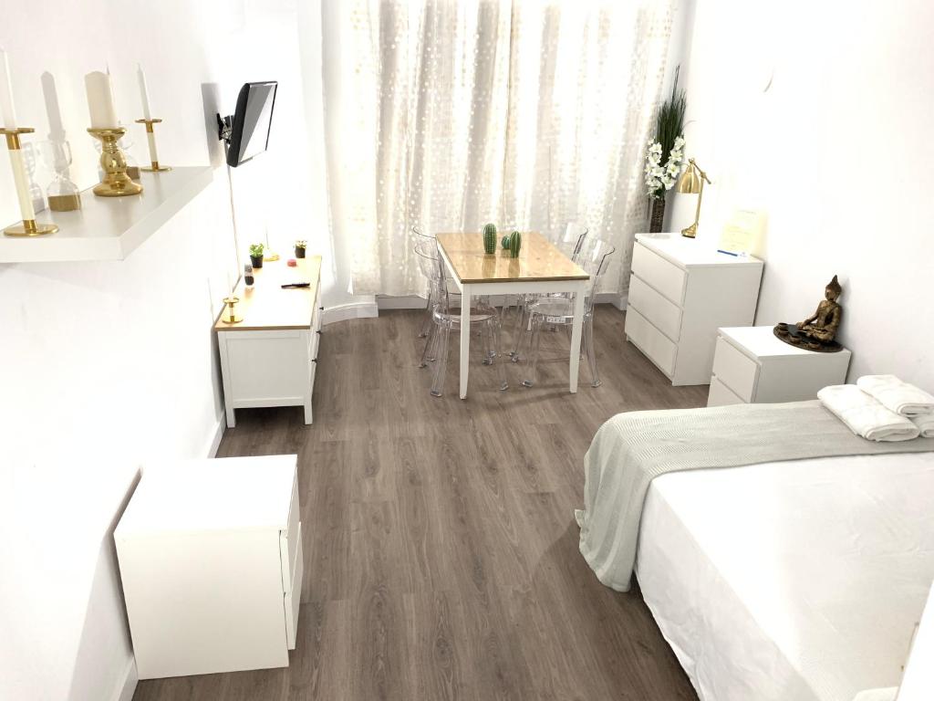 Dormitorio blanco con mesa y cama en Triana Luxury Apartament 329, en Sevilla