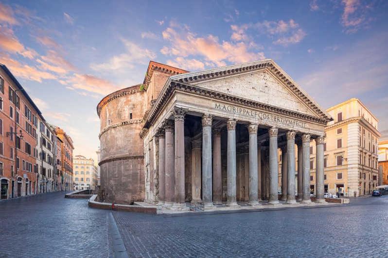 an ancient building with pillars in the middle of a street at Ascanio Twenty Six in Rome