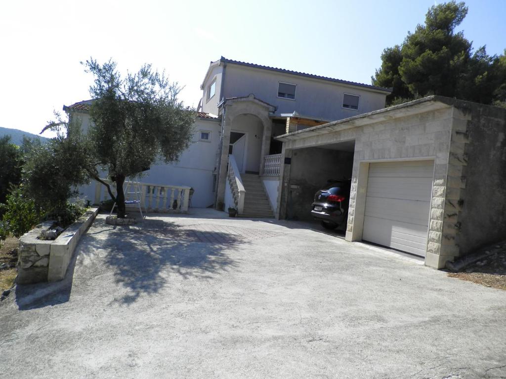 un garage avec une voiture garée devant une maison dans l'établissement Apartments Rinčić, à Marina