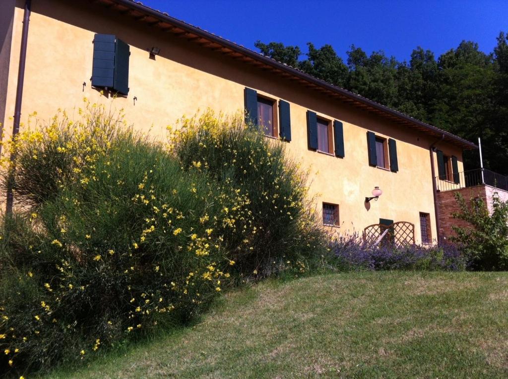 budynek z żółtymi kwiatami przed nim w obiekcie B&B Cal Torello w mieście Urbino
