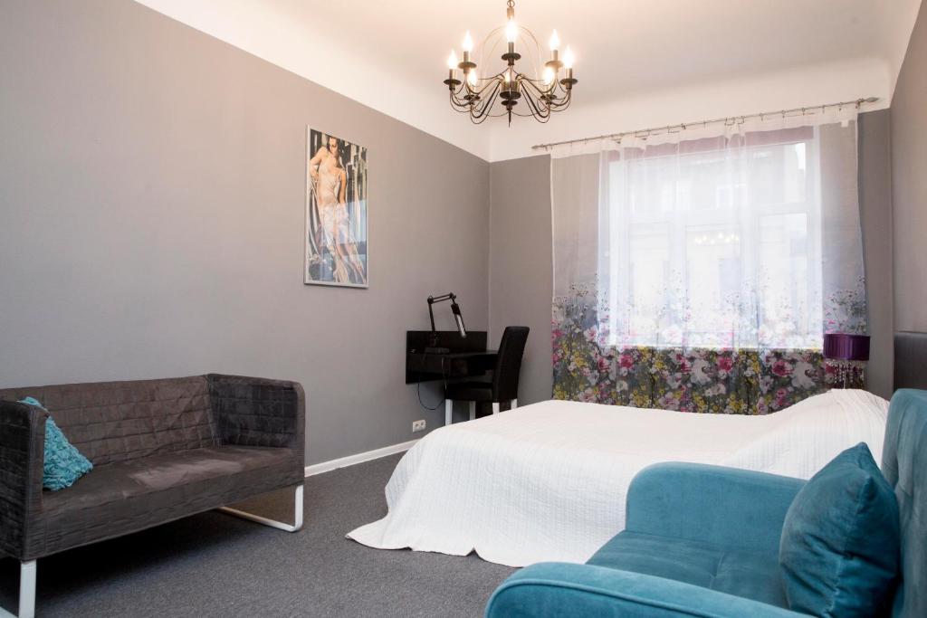 um quarto com uma cama, um sofá e uma janela em Urban Apartment em Riga