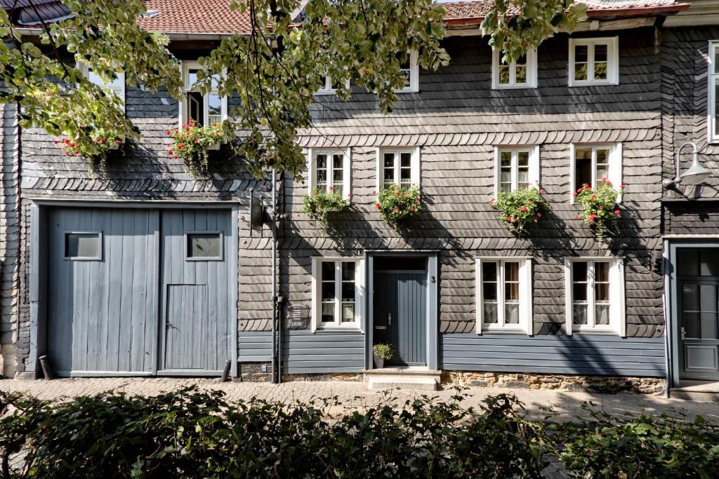 una casa con una puerta de garaje azul y ventanas en Altstadt-Pension Koch, en Goslar