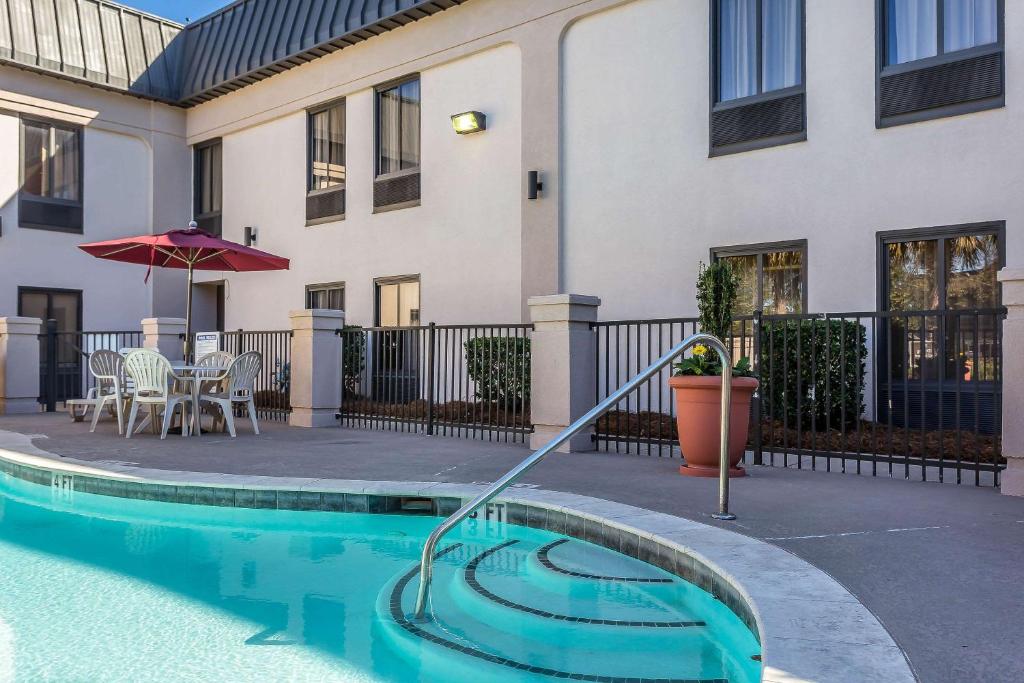 a house with a swimming pool in front of a building at Quality Inn Summerville-Charleston in Summerville