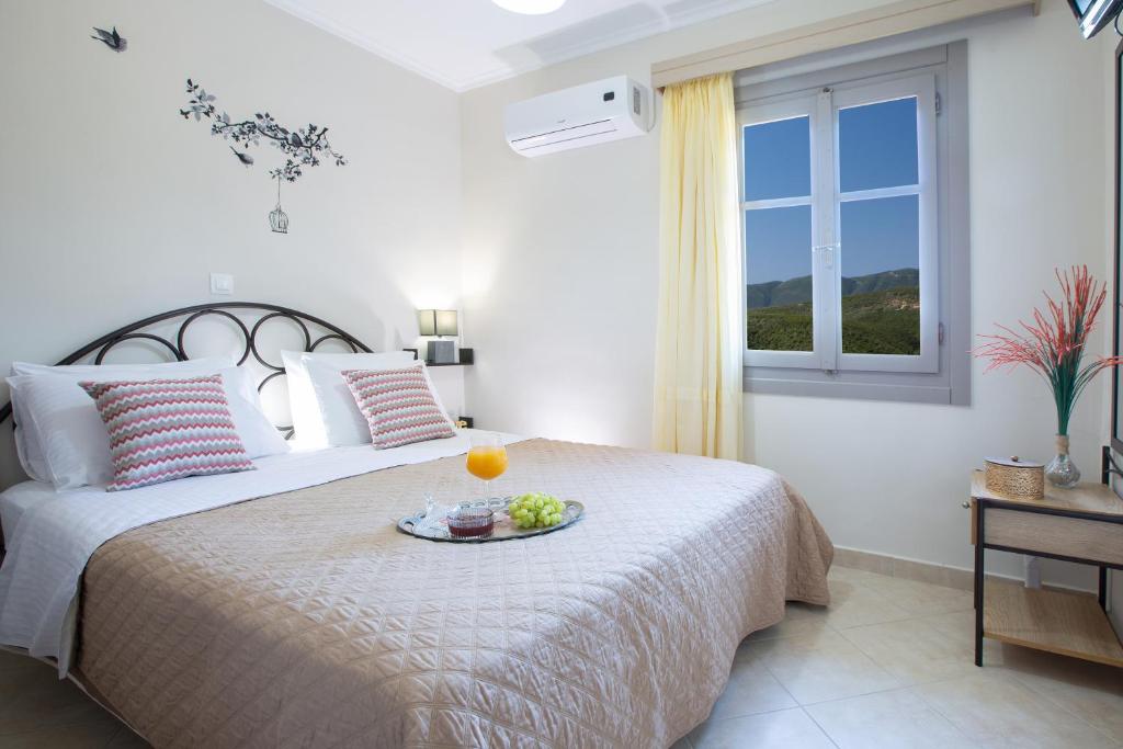 a bedroom with a bed with a tray of fruit on it at George Poros house in Poros