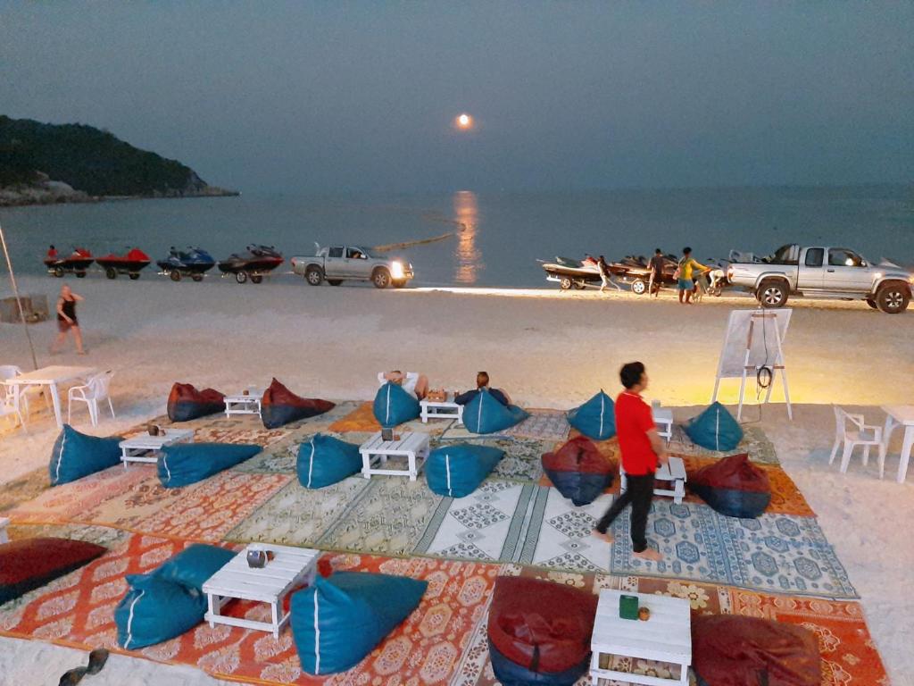 a group of people sitting on a beach at Sunrise Resort- Koh Phangan - SHA Extra Plus in Haad Rin
