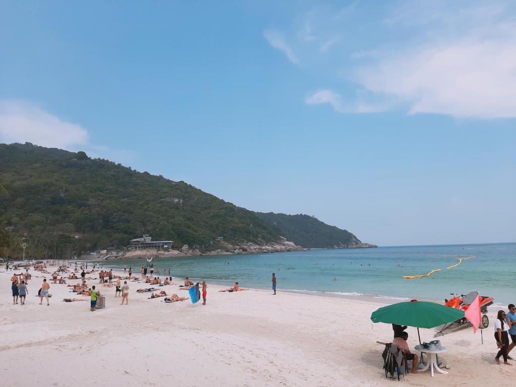 a group of people on a beach with the ocean at Sunrise Resort- Koh Phangan - SHA Extra Plus in Haad Rin