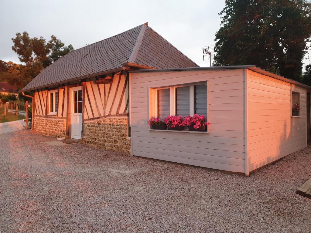 un pequeño cobertizo con flores en una ventana en Gîte YZEN près de Honfleur, en Conteville