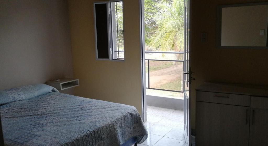 1 dormitorio con 1 cama y puerta a una ventana en Las Piedras del Paso en Paso de la Patria