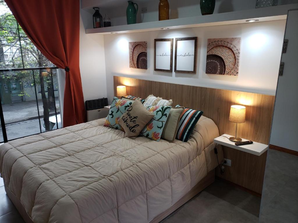 Un dormitorio con una cama grande con almohadas. en DEPARTAMENTO VERA MUJICA 2 cochera propia incluida en Rosario