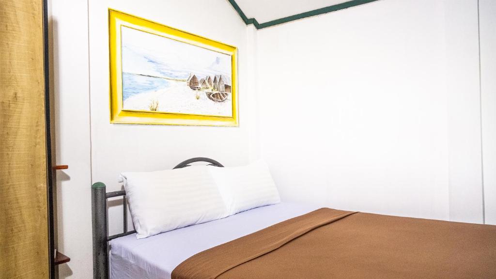 1 dormitorio con 1 cama y una foto en la pared en Sabina Guesthouse, en Kamala Beach