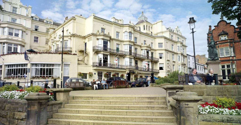a large stone building with a clock on the side of it at Royal Hotel in Scarborough
