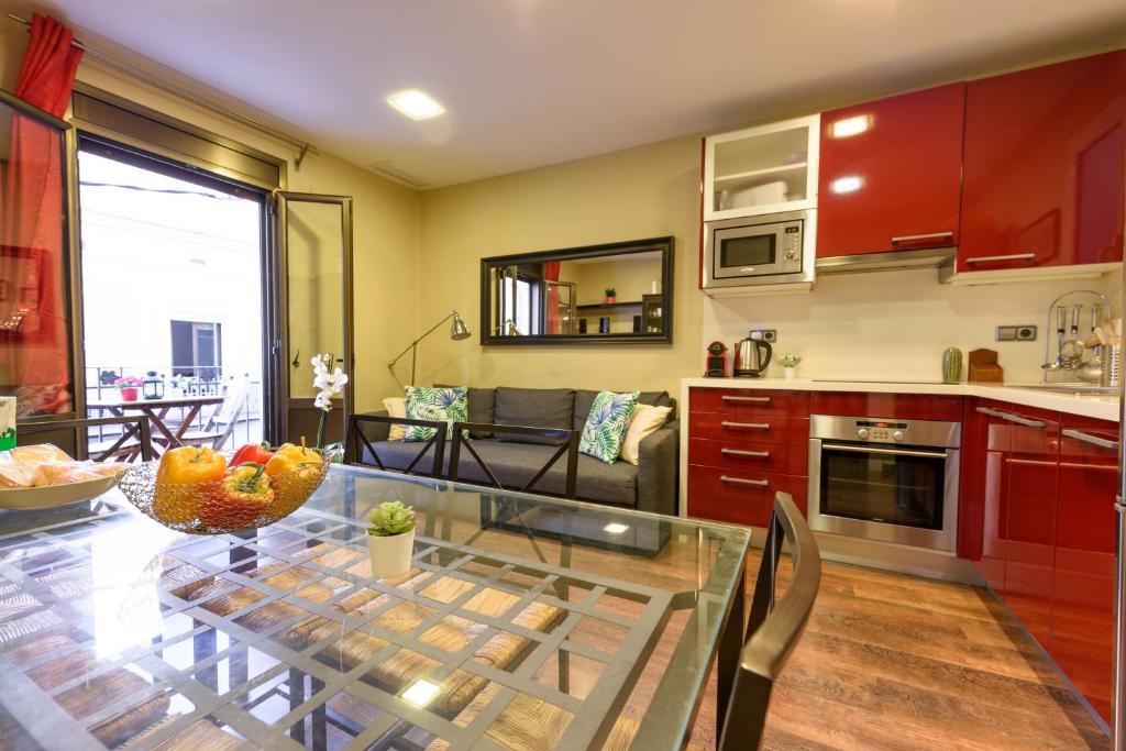 a kitchen with a glass table with a bowl of fruit on it at RamblasRentals Cozy Renovated 2BR with Balcony Lift 20M Rambla - Parking - Wifi in Barcelona