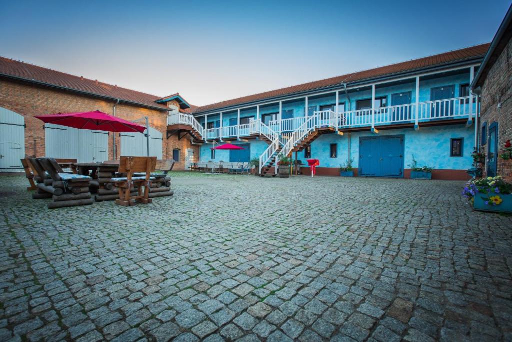 un patio con mesas y sillas y un edificio en Gutshof Dragefeld, en Krzyż