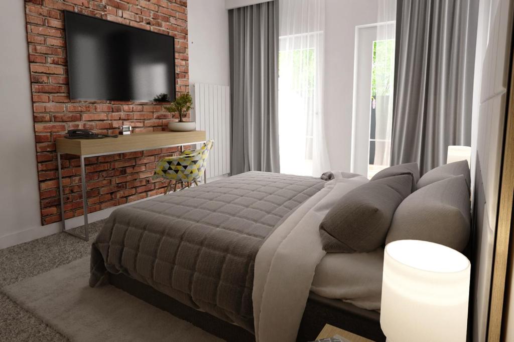 1 dormitorio con cama y pared de ladrillo en ApartAmenty Gostyń en Gostyń